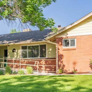 A suburban house with a well-maintained lawn and brick exterior.