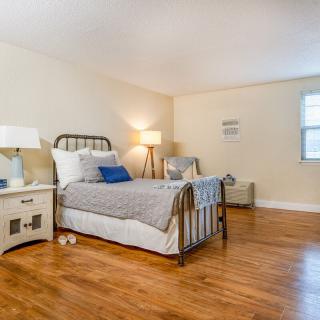 A cozy bedroom with a metal frame bed, hardwood flooring, and soft lighting.