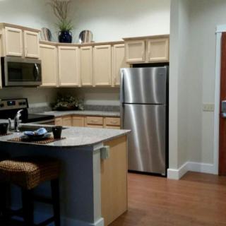 A modern kitchen with stainless steel appliances and light wood cabinets.