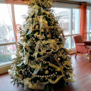 A beautifully decorated Christmas tree adorned with ribbons and ornaments, brightening up the indoor space.
