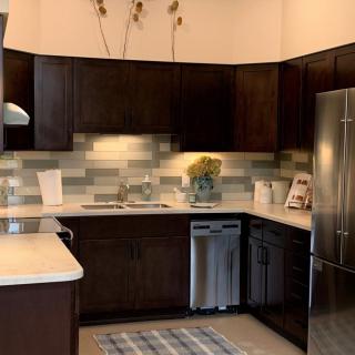 A modern kitchen featuring dark cabinets and stainless steel appliances.