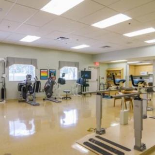 A modern gym with various exercise equipment and a spacious, clean interior.