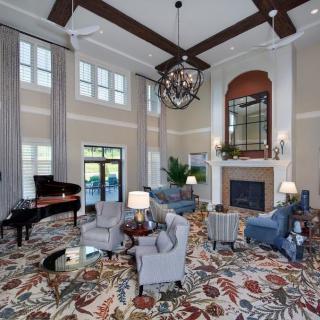 Spacious living room with elegant decor, featuring a grand piano and fireplace.