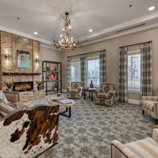 A cozy living room with elegant furniture, a fireplace, and a chandelier.