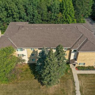 Aerial view of a residential building surrounded by greenery.