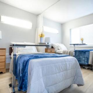 A modern and clean hospital room with two beds and medical equipment.