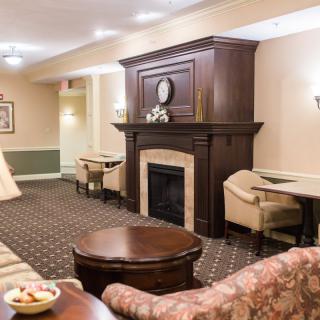 A cozy lounge with comfortable seating and a classic fireplace.