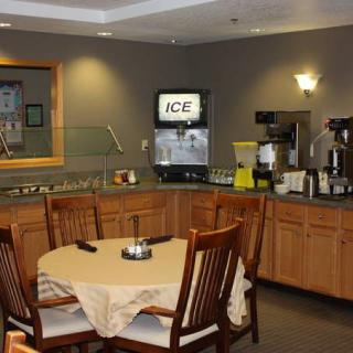 A cozy kitchen and dining area with a table, chairs, ice machine, and coffee station.