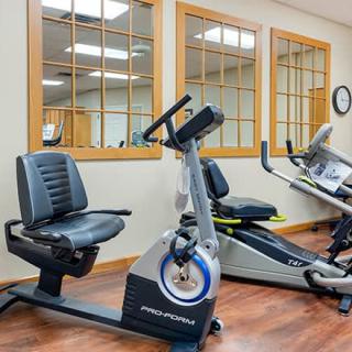 A gym featuring stationary bikes and other cardio equipment in a well-lit room.