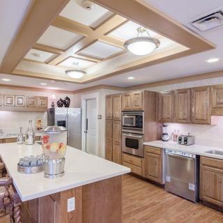 A spacious modern kitchen with wooden cabinets and a large island countertop.
