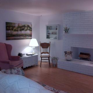 Cozy living room with a chair, lamp, and fireplace.