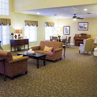 A cozy living room with sofas, chairs, and a carpeted floor.