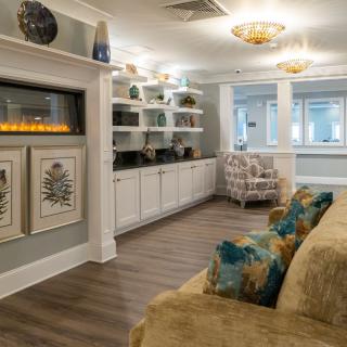 A modern living room featuring a fireplace, decorated with artwork and stylish furniture.