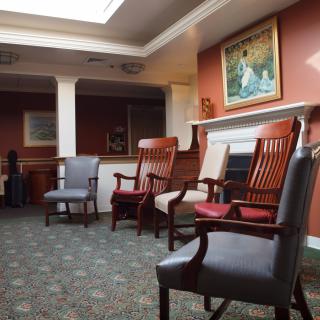 A quiet waiting room with several chairs and a painting on the wall.