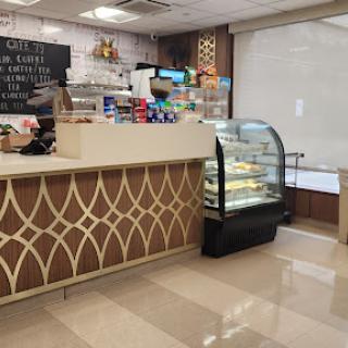 An inviting cafe interior featuring a dessert display and a stylish counter.