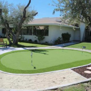 A home garden featuring a putting green with artificial turf.