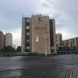 A modern building stands against a cloudy sky, showcasing urban architecture.
