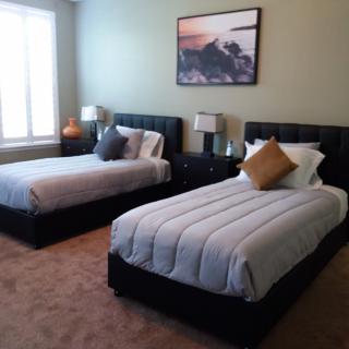 A neatly arranged bedroom with twin beds and elegant decor.