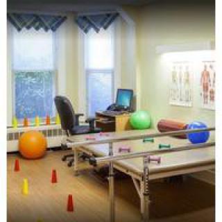 A therapy room equipped with exercise balls and treatment tables for physical rehabilitation.