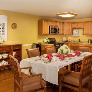 A cozy dining area with a beautifully set table, nestled in a warm-toned kitchen.