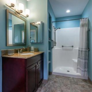 A modern bathroom with a shower, vanity, and stylish lighting.