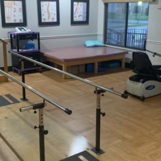 A physical therapy room equipped with parallel bars and exercise equipment.