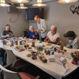 A group of seniors engages in a crafting session, showcasing their creativity and enjoying time together.