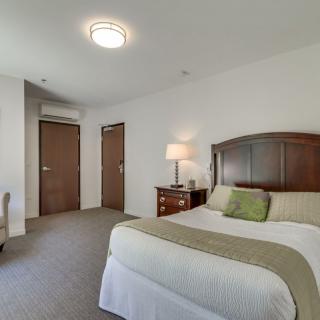 A modern hotel room with a neatly made bed and elegant furnishings.