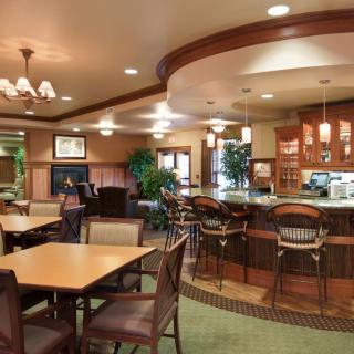 A cozy restaurant interior with a bar counter, tables, and chairs.