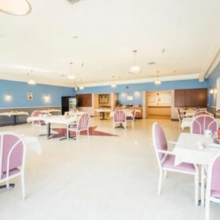 A spacious and well-lit dining area with neatly arranged tables and chairs.