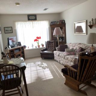 A cozy living room with comfortable furniture and a large window letting in natural light.