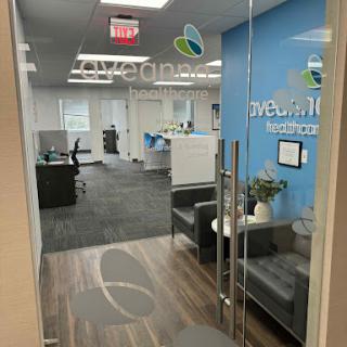 A modern office space featuring a reception area with blue walls and comfortable seating.