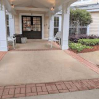 A welcoming entrance to a building with chairs and a small garden.