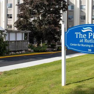 Exterior view of a nursing home with a sign in the front.
