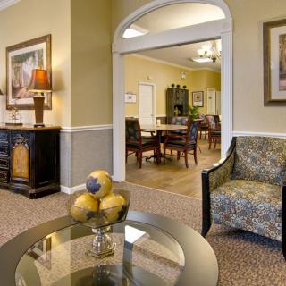 A cozy living room with elegant decor, featuring a glass coffee table, comfortable seating, and warm lighting.
