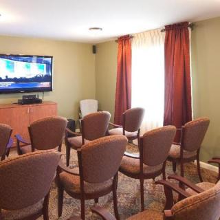 A small conference room with chairs arranged in rows facing a television.