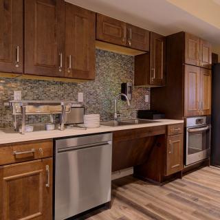 A modern kitchen featuring wood cabinets, stainless steel appliances, and a tile backsplash.