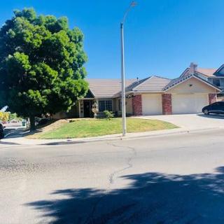 A suburban house with a well-maintained lawn on a sunny day.