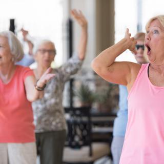 A group of seniors participating in a fitness class indoors.