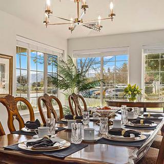 A beautifully set dining room table with elegant decor and abundant natural light.