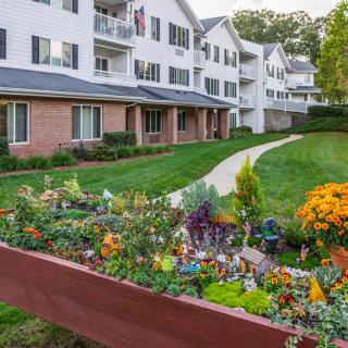 A residential apartment complex with a beautifully landscaped garden and pathway.