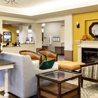 A modern hotel lobby with cozy seating and a fireplace.