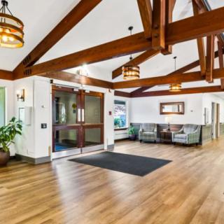 A modern lobby with wooden beams, a seating area, and decorative lighting.