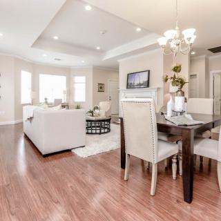 A modern open-concept living and dining area with hardwood flooring and neutral colors.