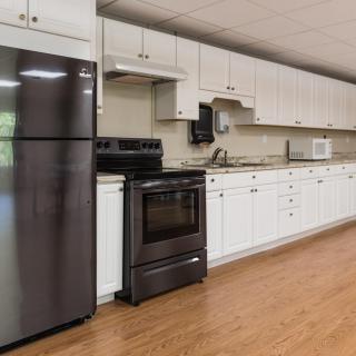 A modern kitchen with white cabinets and stainless steel appliances.