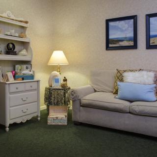 A cozy living room with a sofa, lamp, and decorative elements.