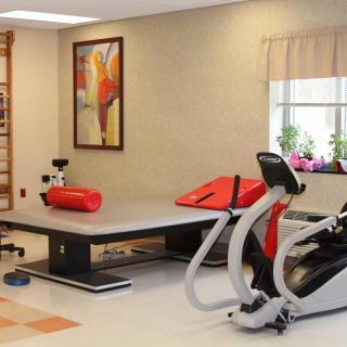 A well-equipped physical therapy room with various exercise machines and equipment.