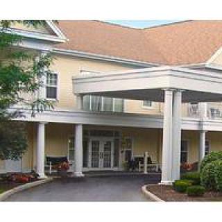 Front entrance of a building with columns and landscaping.