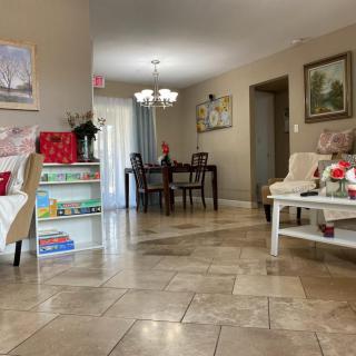 A cozy living room opens into a dining area, featuring elegant furniture and tasteful home decor.