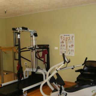 A home gym equipped with a treadmill, elliptical, and workout poster on the wall.